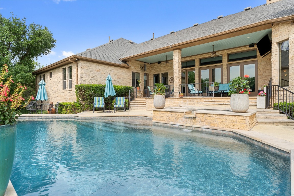 a view of a house with swimming pool and a porch with furniture