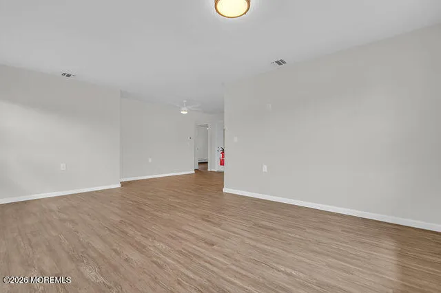 a view of an empty room with wooden floor
