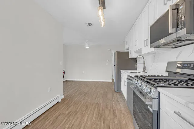 a kitchen with granite countertop a stove and a wooden floor