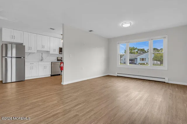 a view of kitchen with wooden floor electronic appliances and window