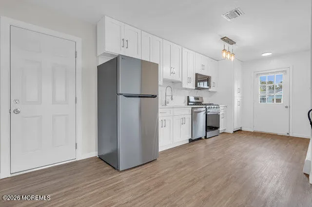 a kitchen with stainless steel appliances a refrigerator sink and cabinets