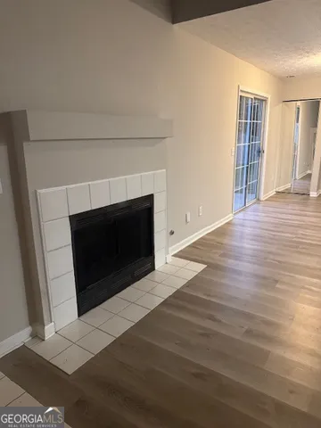 a living room with a fireplace and wooden floor