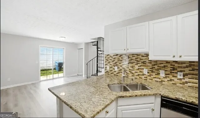 a kitchen with granite countertop sink cabinets and window