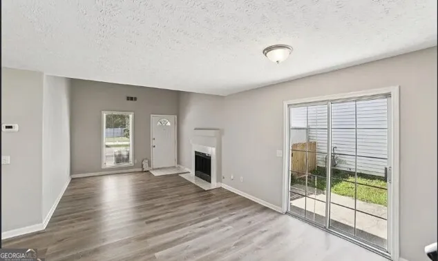 a view of a livingroom with wooden floor and a fireplace