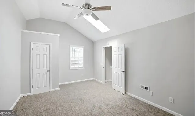 a view of a big room with windows and chandelier fan