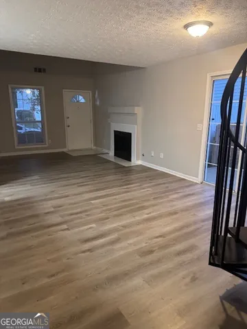 an empty room with wooden floor and fireplace