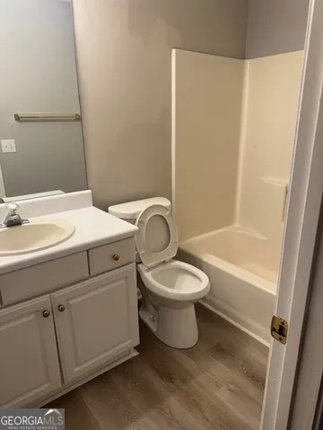 a bathroom with a white toilet sitting next to a white sink and vanity