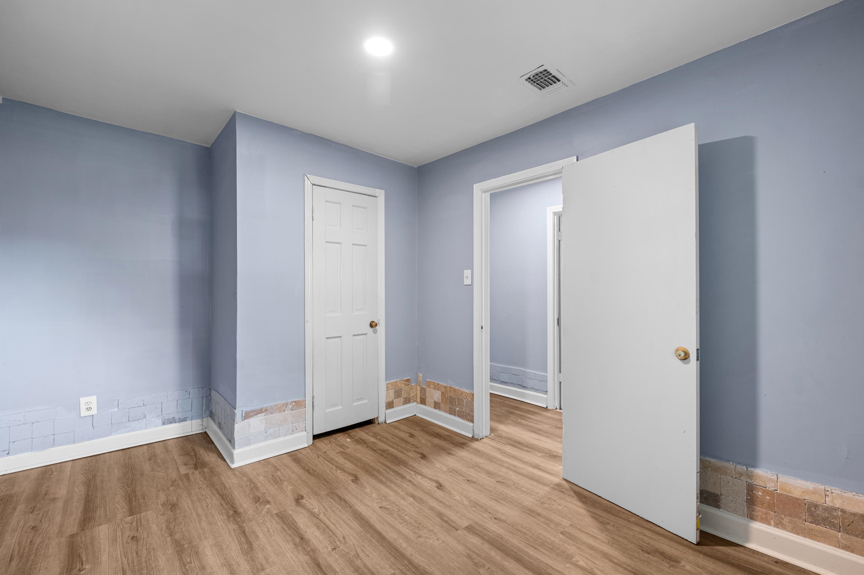 a view of an empty room with wooden floor
