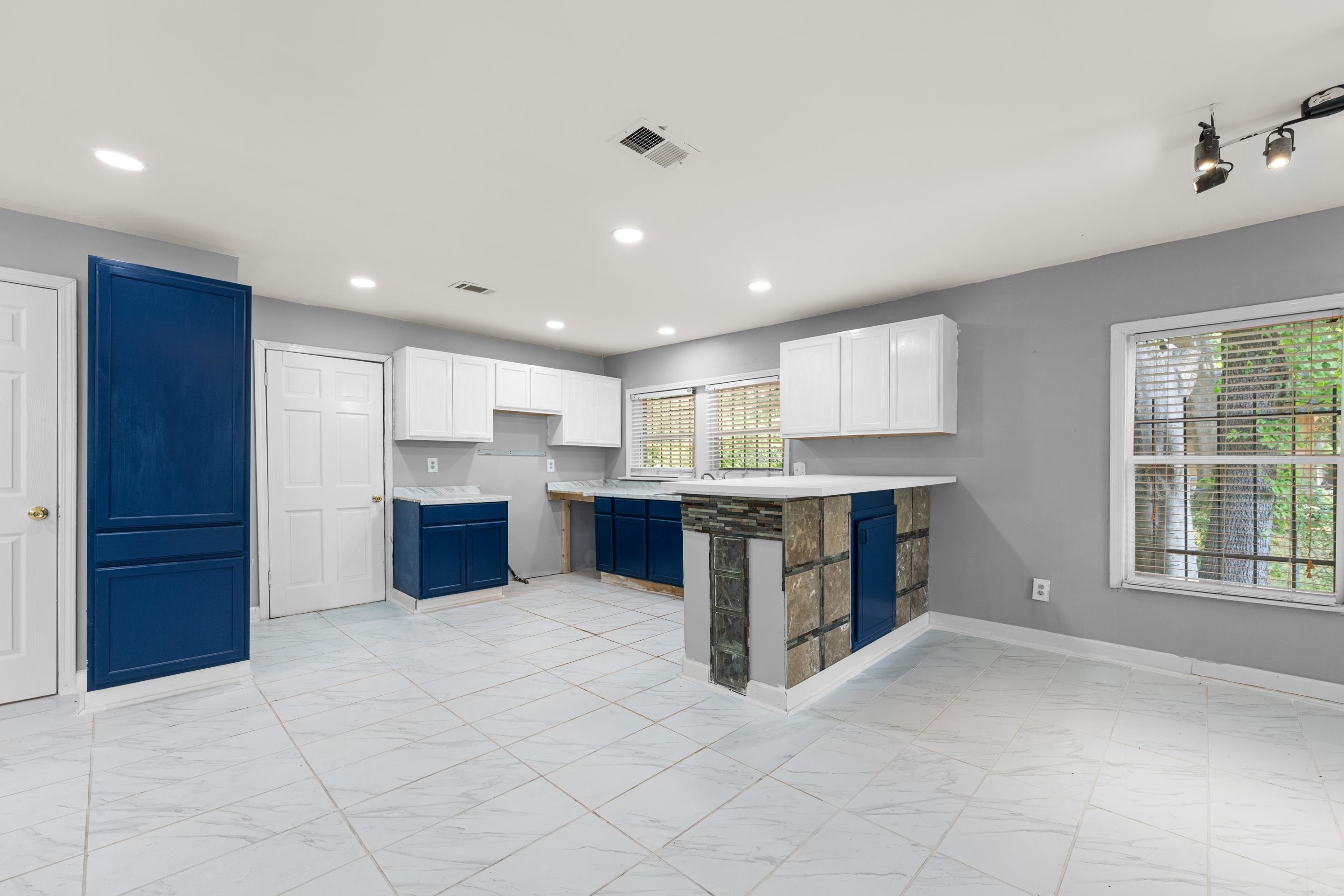 726 Harahan Road Memphis, TN 38109 - Photo 11 of 24 Kitchen featuring light marble finish flooring, white cabinets, light countertops, and recessed lighting