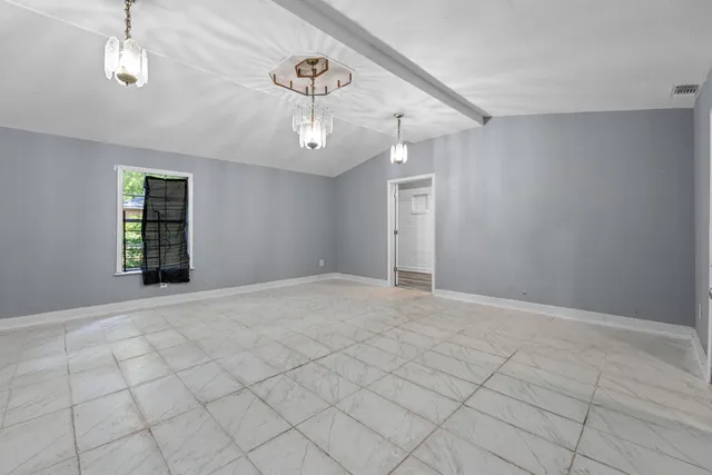 a large white kitchen with a open kitchen island a sink a window and stainless steel appliances