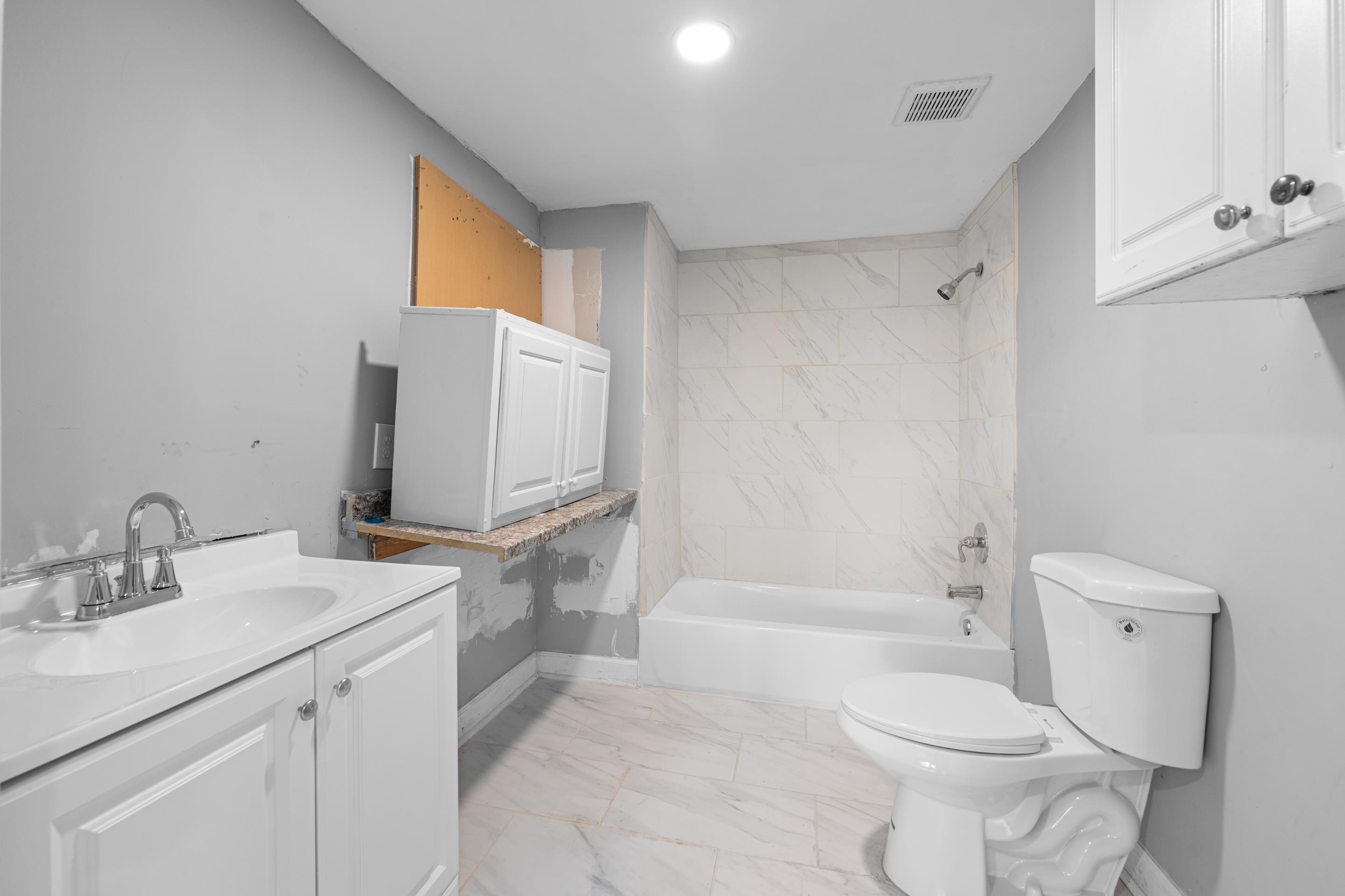 726 Harahan Road Memphis, TN 38109 - Photo 22 of 24 Bathroom with marble look tiles, vanity, and bathing tub / shower combination