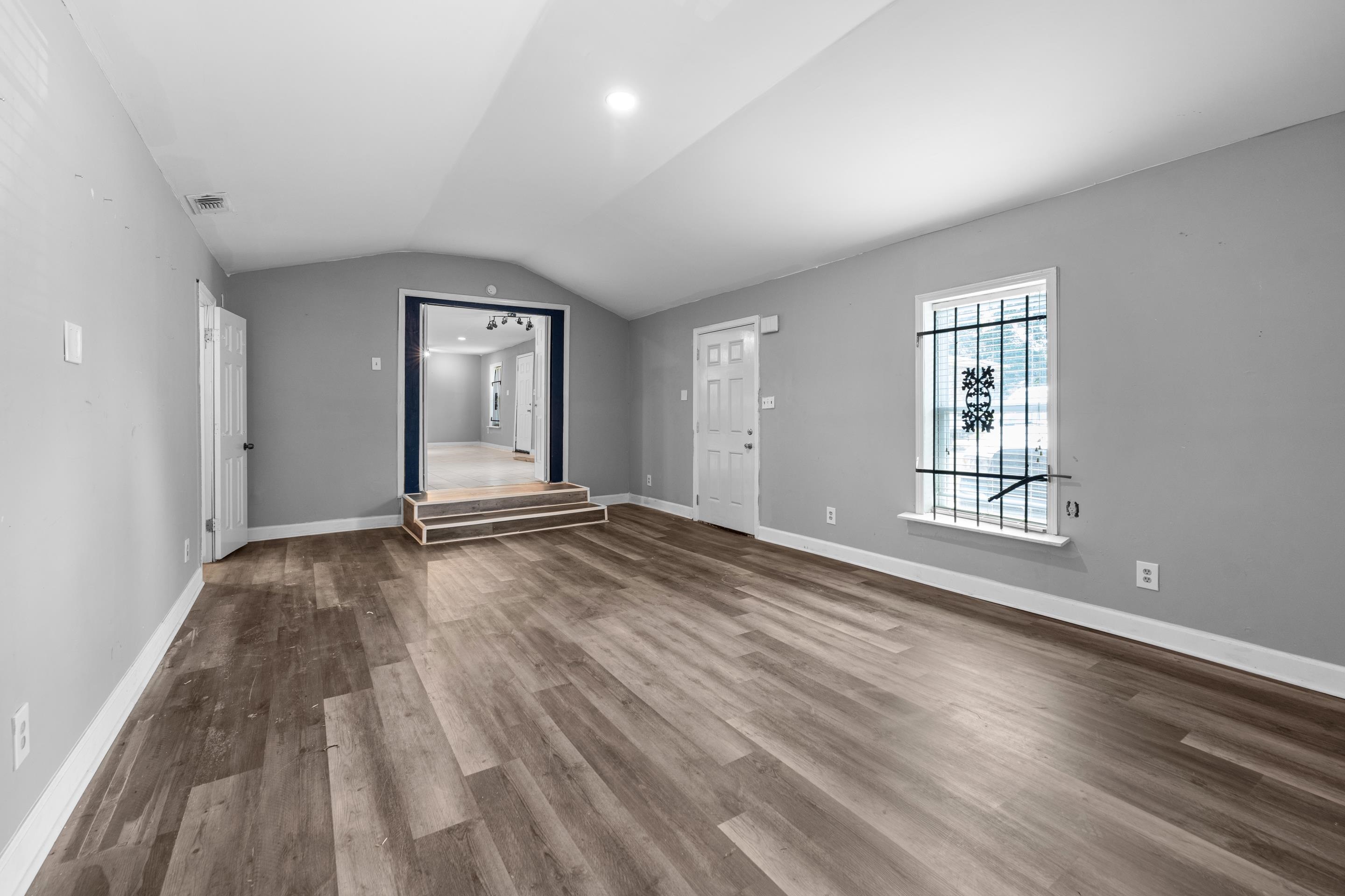 726 Harahan Road Memphis, TN 38109 - Photo 5 of 24 Unfurnished living room with wood finished floors and lofted ceiling
