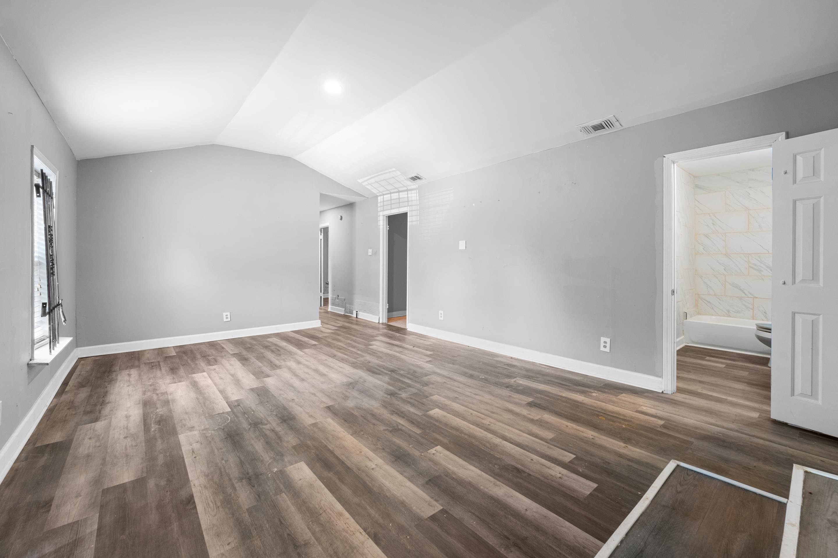 726 Harahan Road Memphis, TN 38109 - Photo 6 of 24 Unfurnished living room with wood finished floors and lofted ceiling
