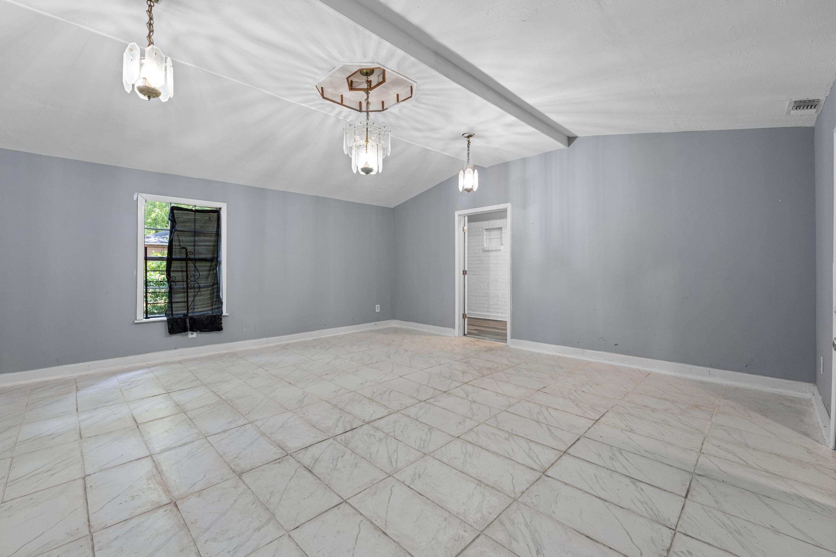 726 Harahan Road Memphis, TN 38109 - Photo 8 of 24 Empty room with baseboards and a chandelier