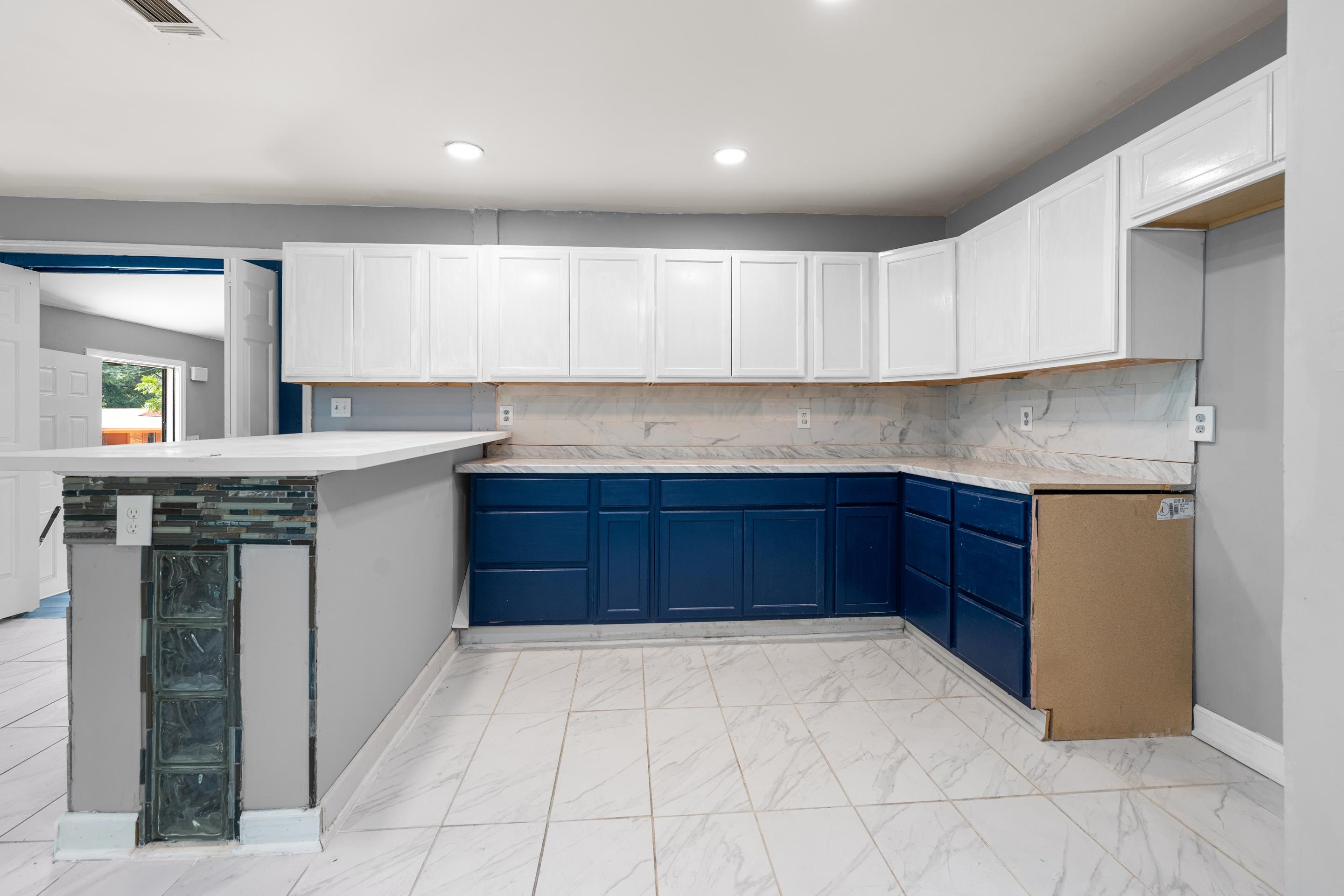 726 Harahan Road Memphis, TN 38109 - Photo 10 of 24 Kitchen with blue cabinets, decorative backsplash, light countertops, white cabinets, and recessed lighting