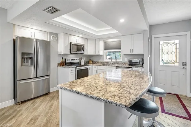 a kitchen with kitchen island a counter space stainless steel appliances and cabinets