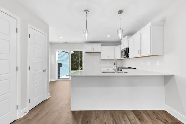 a view of a kitchen with kitchen island a sink stainless steel appliances and cabinets