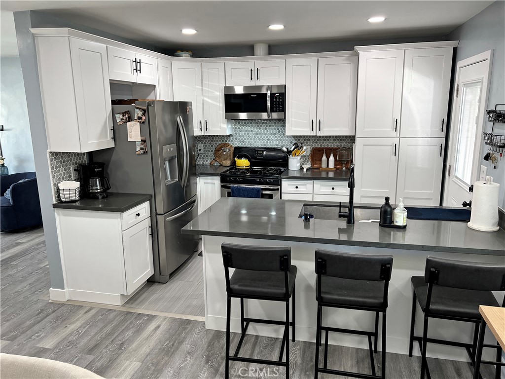 a kitchen with stainless steel appliances a stove refrigerator sink and microwave