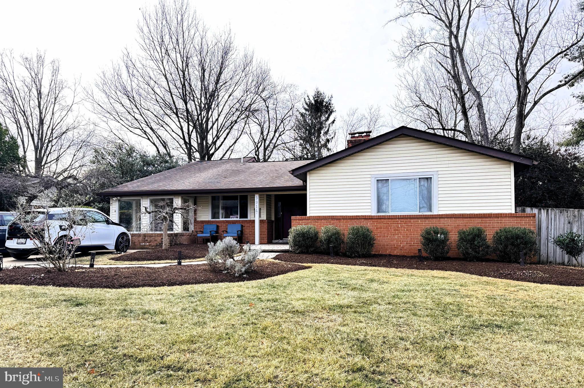 9914 Fernwood Road Bethesda, MD 20817 - Photo 2 of 3 a front view of a house with a yard and seating space