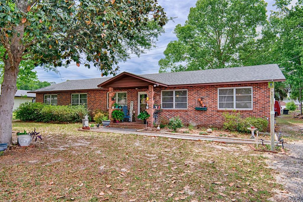 6537 Triest Avenue Keystone Heights, FL 32656 - Photo 1 of 36 a front view of a house with a yard and potted plants