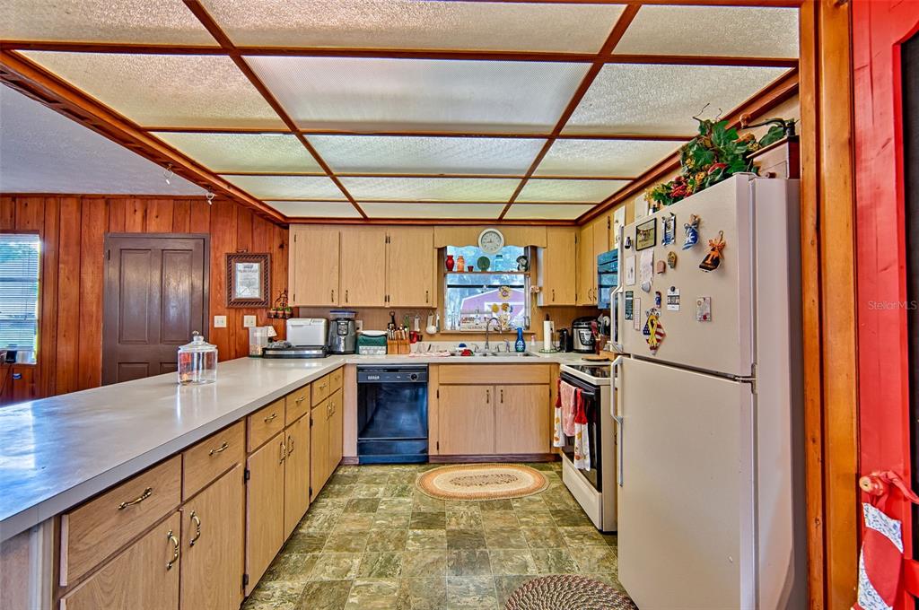 6537 Triest Avenue Keystone Heights, FL 32656 - Photo 11 of 36 a kitchen with refrigerator and cabinets