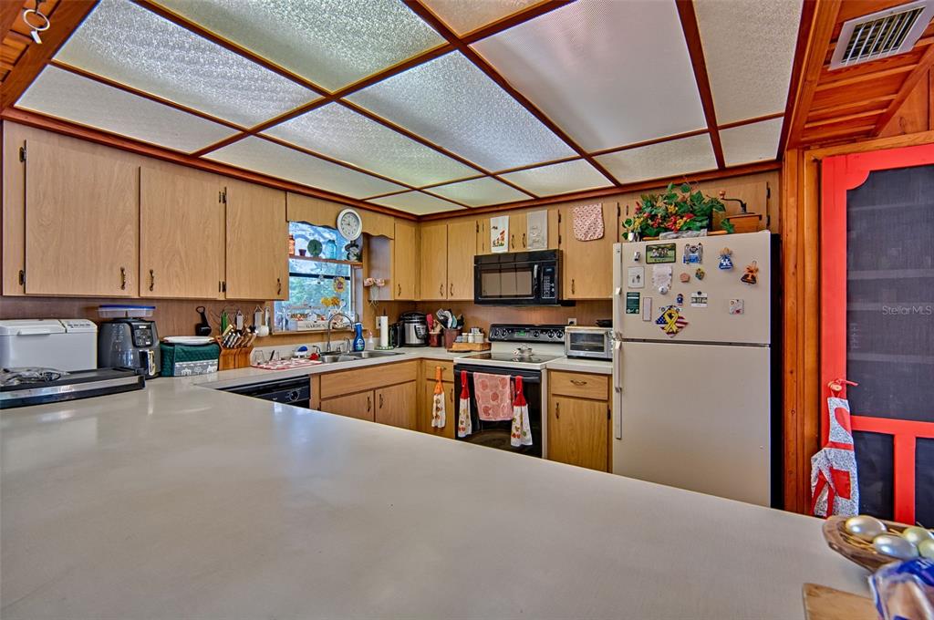 6537 Triest Avenue Keystone Heights, FL 32656 - Photo 15 of 36 a kitchen with stainless steel appliances granite countertop a refrigerator a stove top oven a sink and dishwasher
