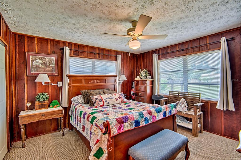 6537 Triest Avenue Keystone Heights, FL 32656 - Photo 16 of 36 a bedroom with a bed and a chandelier