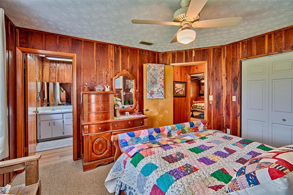 6537 Triest Avenue Keystone Heights, FL 32656 - Photo 17 of 36 a bedroom with a bed and a chandelier