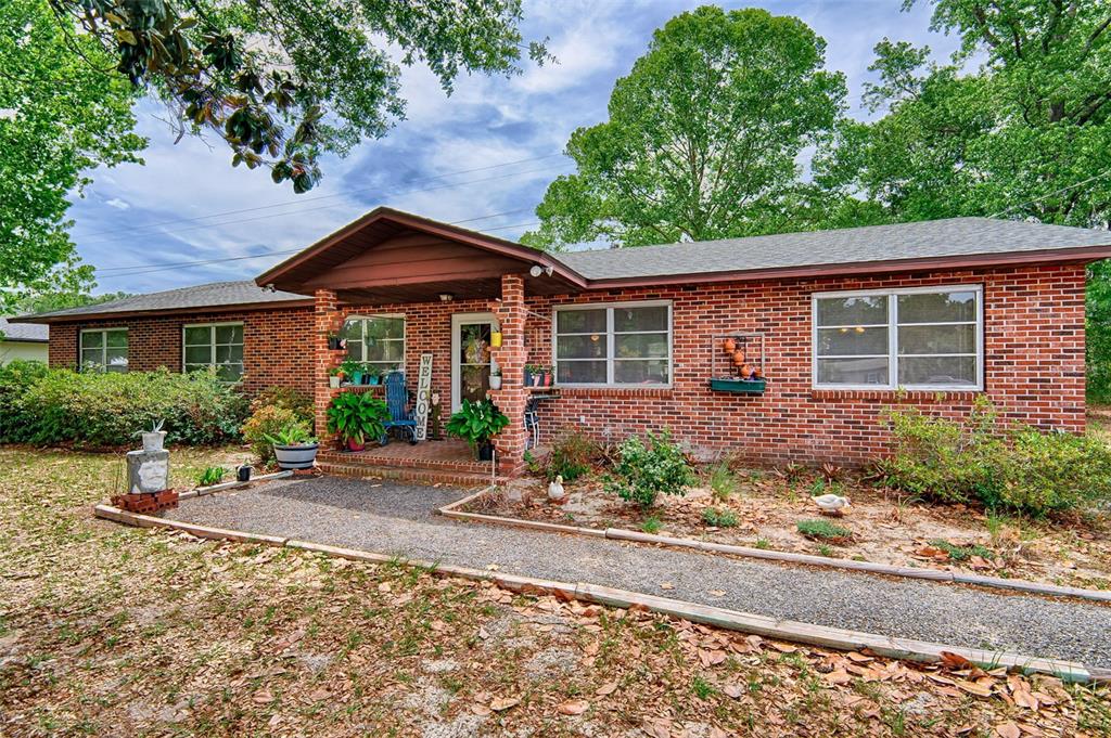 6537 Triest Avenue Keystone Heights, FL 32656 - Photo 36 of 36 a front view of a house with a yard and potted plants