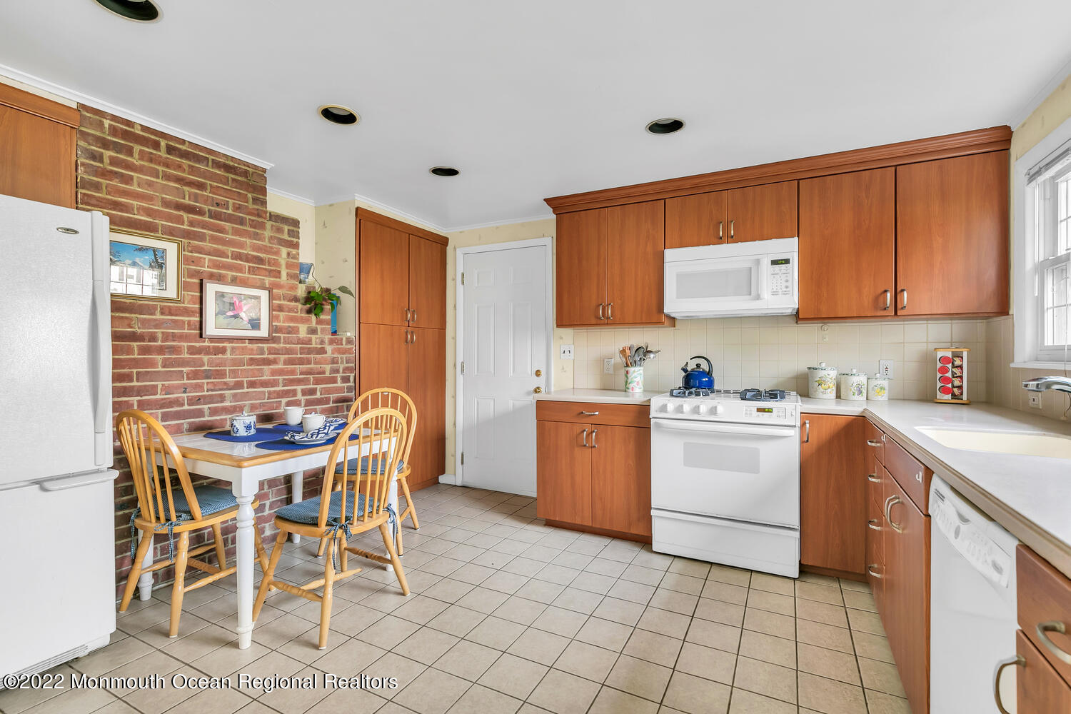 1207 Pond Road Spring Lake Heights, NJ 07762 - Photo 2 of 28 a kitchen with a dining table chairs and white appliances
