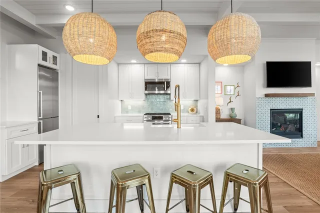 a kitchen with stainless steel appliances a table and chairs in it