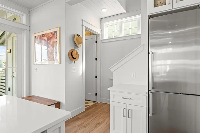 a view of hallway with window and refrigerator