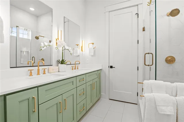 a spacious bathroom with a double vanity sink a mirror and a shower