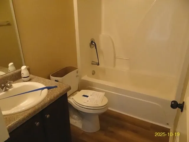 a bathroom with a granite countertop sink and a toilet