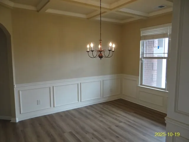 a view of an empty room with chandelier fan and fire place