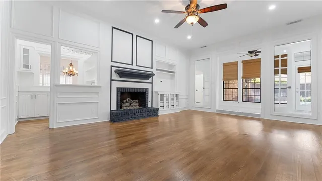 a view of an empty room with wooden floor window and wooden floor