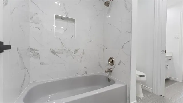 a view of empty room with wooden floor and ceiling fan