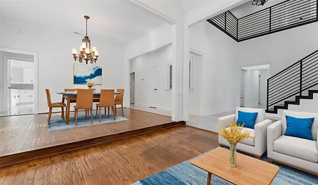 an empty room with wooden floor and chandelier