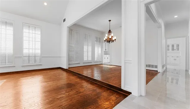 a view of an empty room with wooden floor fireplace and a window