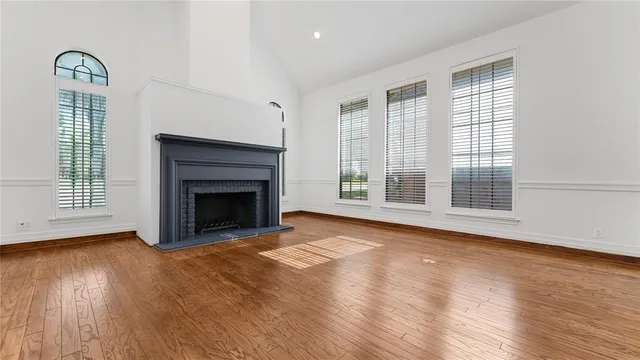 a kitchen with a sink dishwasher a stove and white cabinets with wooden floor