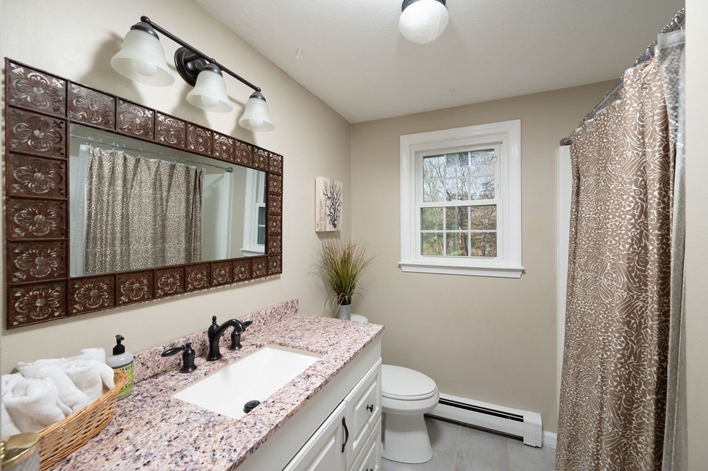 5 Chatham Circle Hingham, MA 02043 - Photo 15 of 30 a bathroom with a granite countertop sink a mirror and a toilet