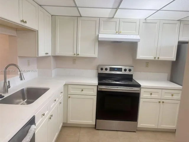 a kitchen with white cabinets and a stove top oven