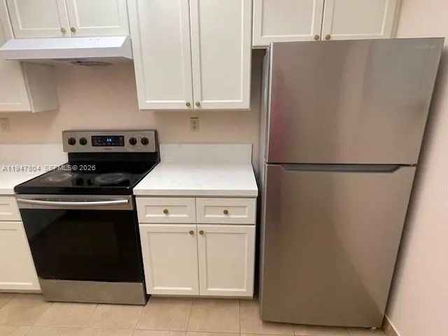a white refrigerator freezer and a stove sitting inside of a kitchen