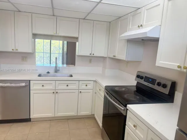 a kitchen with white cabinets and a stove