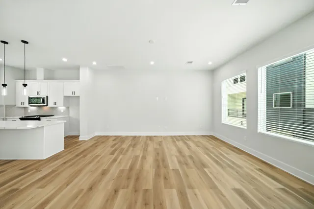 a view of a kitchen with a sink and dishwasher a refrigerator with wooden floor