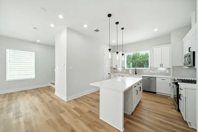a large kitchen with kitchen island a sink stainless steel appliances and cabinets