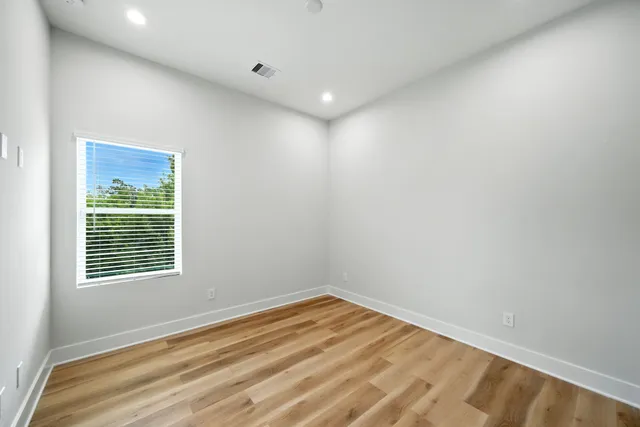 a view of empty room with wooden floor