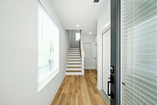 a view of a hallway with wooden floor and staircase