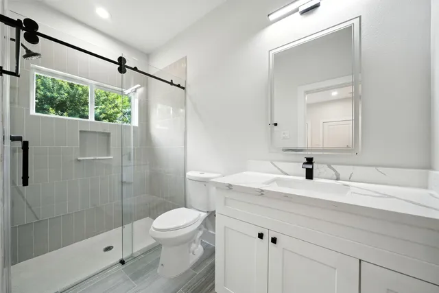 a bathroom with a sink toilet a mirror and shower