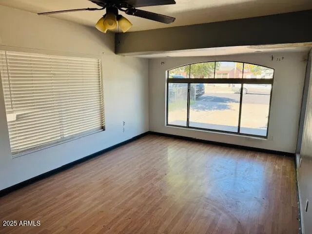 an empty room with a window and ceiling fan